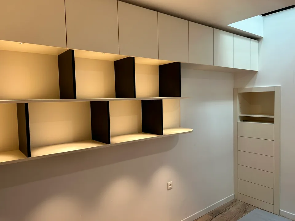 Bibliothèque sur-mesure avec niches en bois sombre et éclairage intégré, réalisation MZ Bois et Compagnie