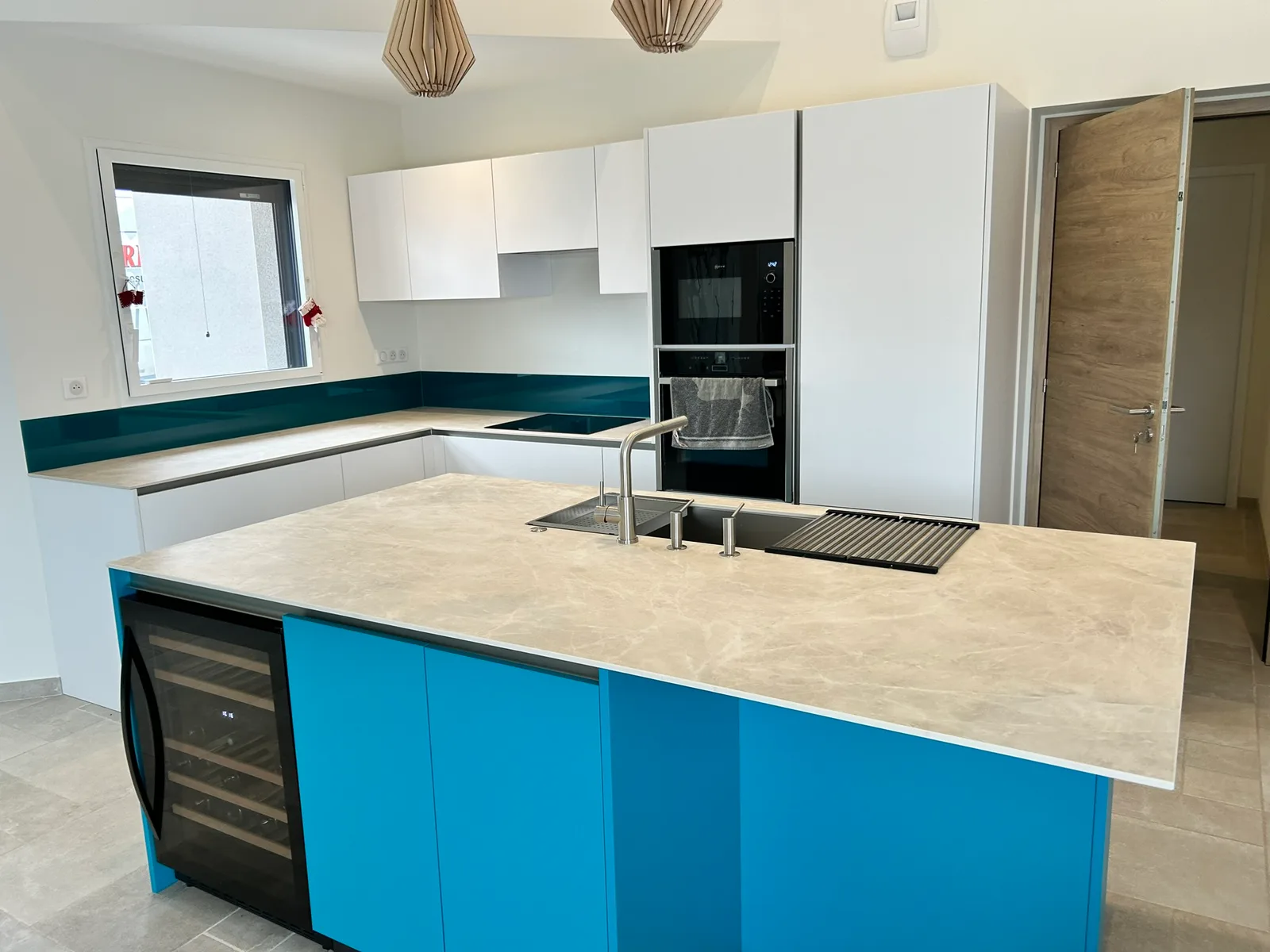 Îlot de cuisine bleu paon avec cave à vin intégrée, réalisation MZ Bois et Compagnie
